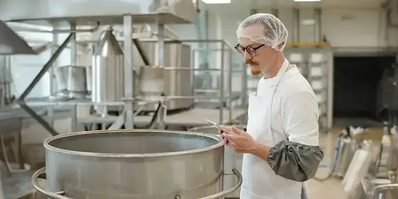 Technicien agroalimentaire inspectant une cuve inox, conformité HACCP.